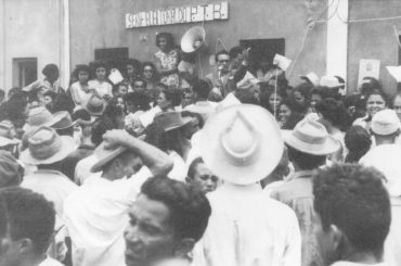 Na foto, de 1954, o líder sindical Floriano Bezerra de Araújo, com impecável paletó de casimira inglesa, comprado no Rio de Janeiro, fala ao povo de Macau em sua primeira candidatura a deputado estadual, na qual conquistou a 1ª Suplência e teve a honra de assumir o mandato por 30 dias. Essa foi a primeira legislatura de mais duas outras que Floriano venceu de forma integral, até o golpe empresarial-militar de 1964, que cassou seu mandato e suspendeu seus direitos políticos por 18 anos